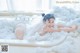 A woman laying in a bathtub covered in foam.