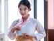 A woman in a pink and white hanbok is posing for a picture.