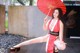 A woman in a red and white kimono holding an umbrella.