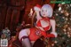 A woman in a red lingerie sitting on a chair next to a Christmas tree.