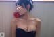 A woman in a black dress holding an apple.